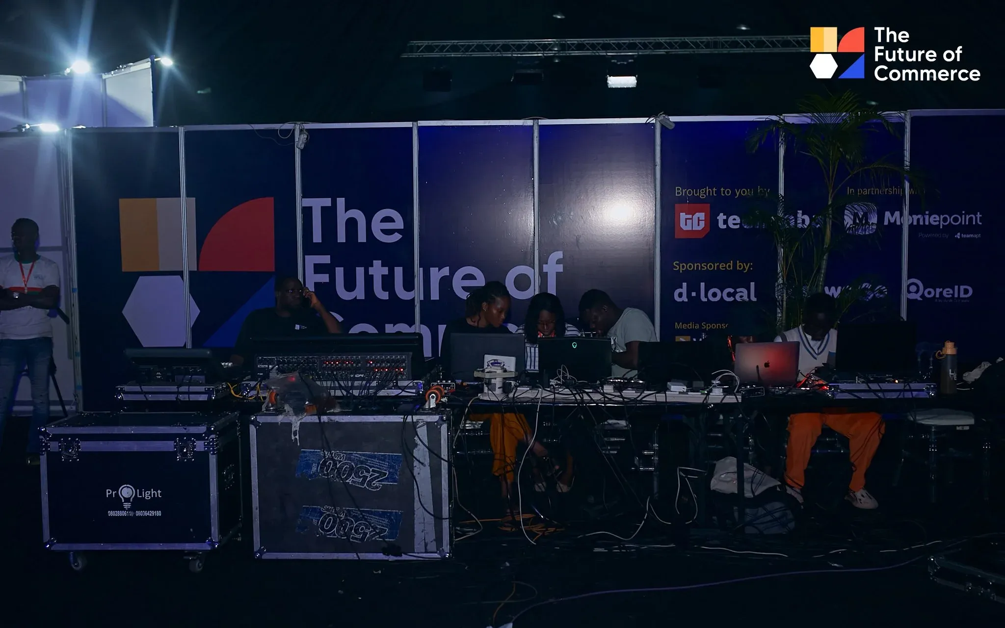 Production desk at The Future of Commerce event with the branded event backdrop behind it.