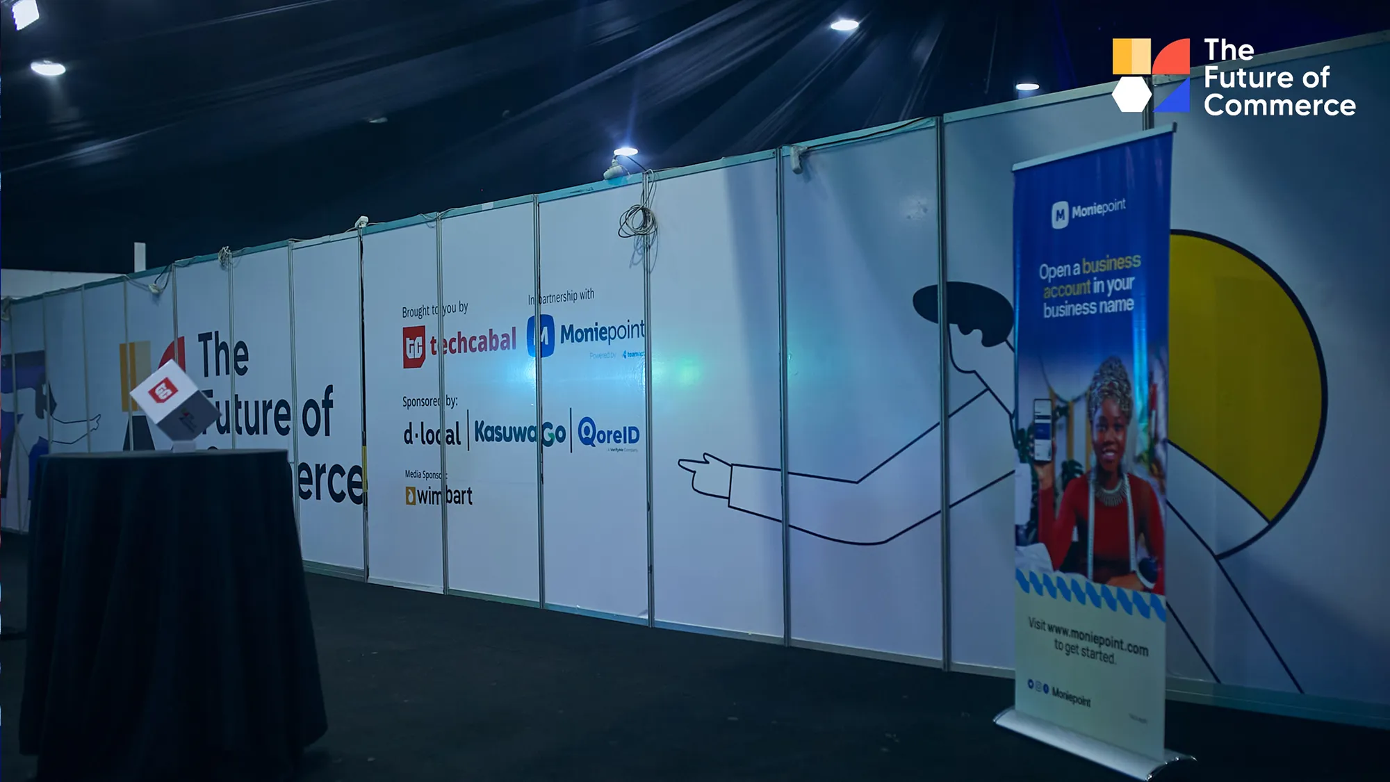 The Future of Commerce event space with branded wall graphics, sponsor signage and a Moniepoint display.